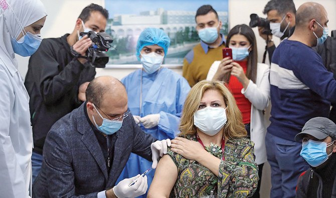 Lebanon’s Health Minister Hamad Hassan administers a dose of the COVID-19 vaccine to a member of the staff at the Rafik Hariri Hospital in Beirut. (File/AFP)