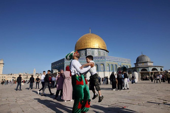 Muslims celebrate after the morning Eid al-Fitr prayer outside the Dome of the Rock mosque in Al-Aqsa in Old Jerusalem early on Friday. (AFP)