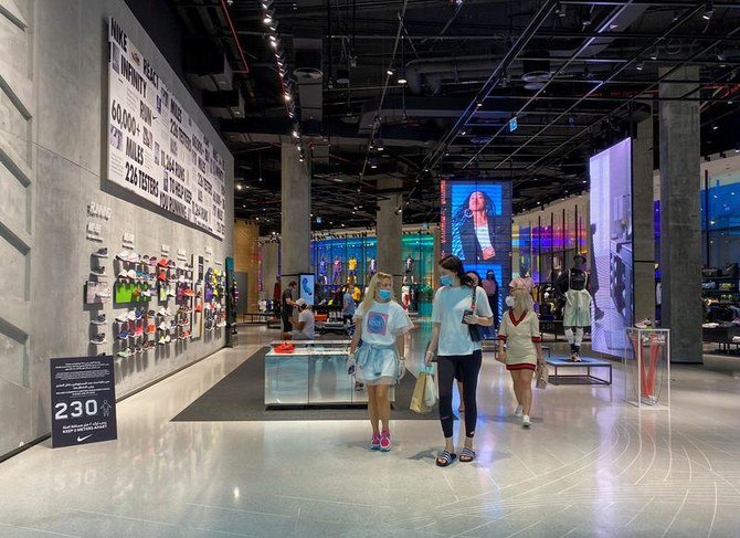 People wearing protective face masks and gloves shop at Dubai mall, May 3, 2020. (Reuters)