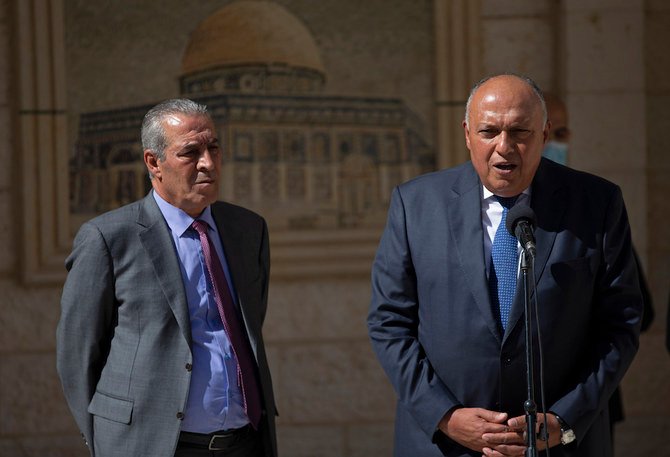 Egyptian FM Sameh Shoukry (right), with Chairman of the Palestinian Civil Affairs Commission Hussein Al-Sheikh, after a meeting with Palestinian President Mahmoud Abbas, in Ramallah, on May 24, 2021. (AP)