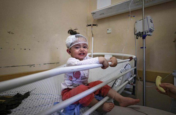 A Palestinian girl, who was wounded in overnight Israeli air strikes on the Gaza Strip, receives treatment at Al-Shifa Hospital in the Palestinian enclave. (File/AFP)