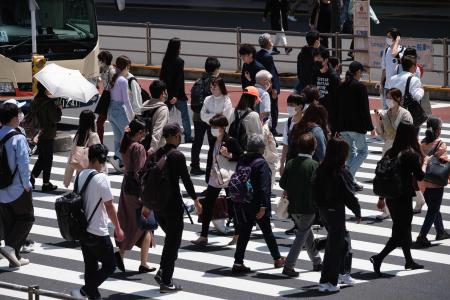 Pedestrians cross a street in Tokyo on April 30, 2021. (AFP)