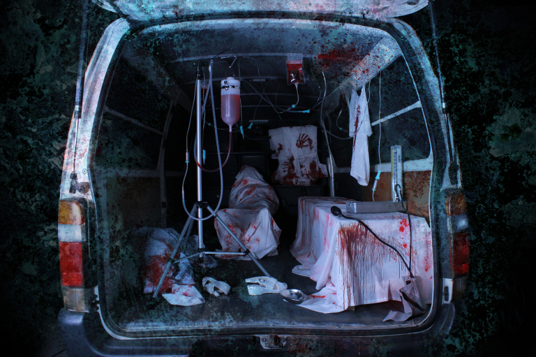 The ambulance appears gruesome and eery, designed to look worn out with rusty metal and stained windows—there are also bloody handprints scattered around for added effect. (Kowagarasetai)