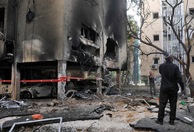 Residents check the damage after a Hamas rocket attack on the central Israeli city of Petah Tikva on May 13, 2021. (AFP)