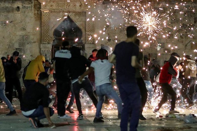 Palestinians react as Israeli police fire stun grenades during clashes at Al-Aqsa Mosque in Jerusalem’s Old City, May 7, 2021. (Reuters)