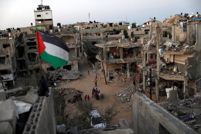 A Palestinian flag flies as the ruins of houses, which were destroyed by Israeli air strikes during the Israeli-Palestinian fighting, are seen, in Gaza Strip, May 25, 2021. Picture taken May 25, 2021. (Reuters)