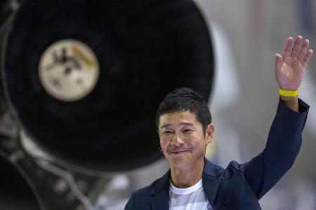 In this file photo taken on September 18, 2018 Japanese billionaire Yusaku Maezawa gestures near a Falcon 9 rocket during the announcement by Elon Musk to be the first private passenger who will fly around the Moon aboard the SpaceX BFR launch vehicle, at the SpaceX headquarters and rocket factory in Hawthorne, California. (AFP)