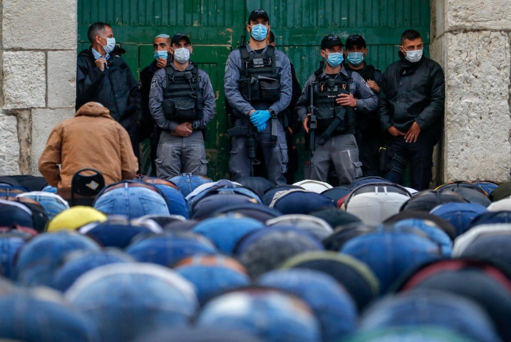 Israeli security forces keep watch as Palestinian worshippers attend the prayers of Eid al-Fitr outside the closed Aqsa mosque complex in Jerusalem on May 24, 2020. (AFP file photo)