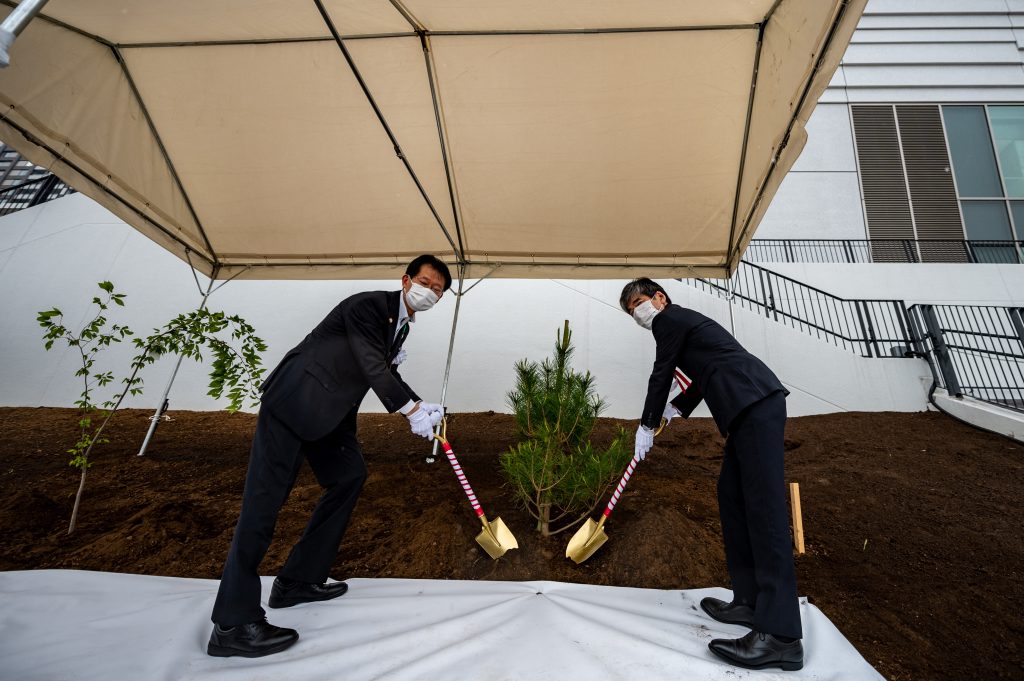 Shozo Hirai (R), director of the Iwate Prefecture Tokyo Office and Tomohide Sato (L), deputy director general, bureau of Olympic and Paralympic Games Tokyo 2020 Preparation, take part in a tree planting event. (AFP)