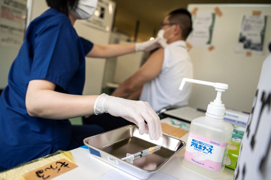 A health worker administers the Moderna Covid-19 coronavirus vaccine during the first round of vaccinations for firefighters in Tokyo on June 8, 2021. (AFP)