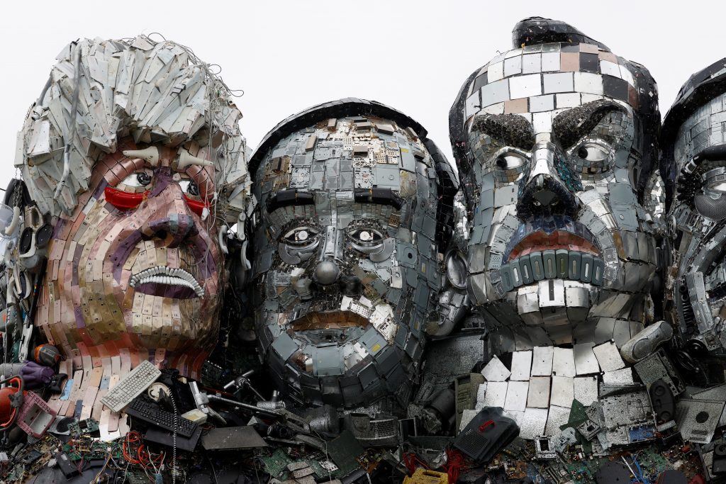 Japan’s Prime Minister SUGA Yoshihide’s face (C) is among the seven sculpted using remnants of electronic devices to highlight their impact on the environment.