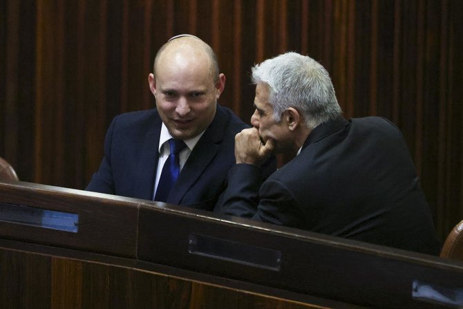Naftali Bennett, left, speaks to Yair Lapid during a special session of the Knesset on Wednesday, June 2, 2021. (AP)
