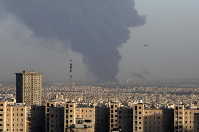 Huge smoke rises up from Tehran’s main oil refinery as a plane approaches Mehrabad airport south of Tehran, Iran, Wednesday, June 2, 2021. (AP)