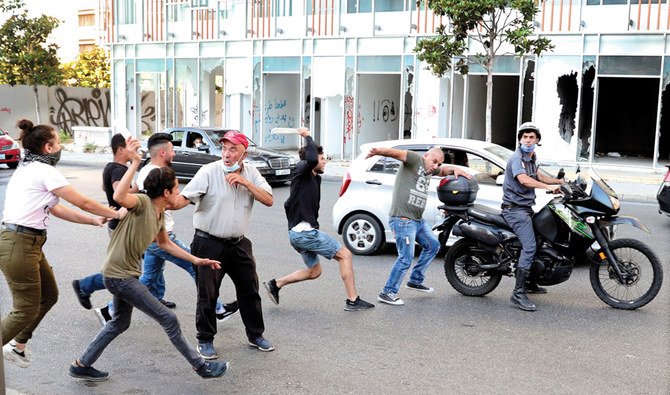 Anti-government protesters attack a member of Lebanese police intelligence in Beirut after they saw him taking pictures of protesters. (File/AP)