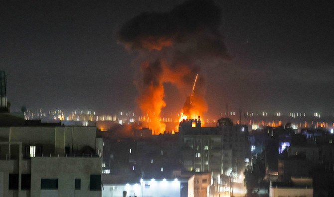 Explosions light-up the night sky above buildings in Gaza City as Israeli forces shell the Palestinian enclave, early on June 16, 2021. (AFP)