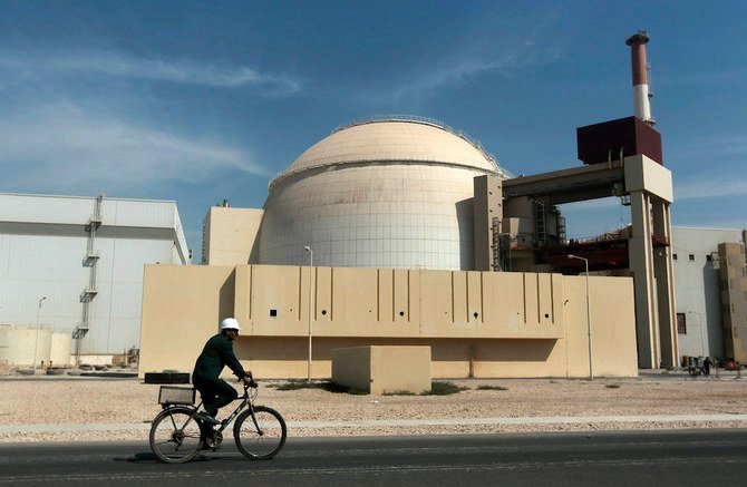 A worker rides a bicycle in front of the reactor building of the Bushehr nuclear power plant, just outside the southern city of Bushehr. (File/AP)