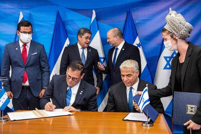 Israeli Foreign Minister Yair Lapid and Honduran Foreign Minister Lisandro sign bilateral agreements as Israeli PM Naftali Bennett speaks with Honduran President Juan Orlando Hernandez at the Prime Minister’s Office in Jerusalem on June 24, 2021. (AFP)