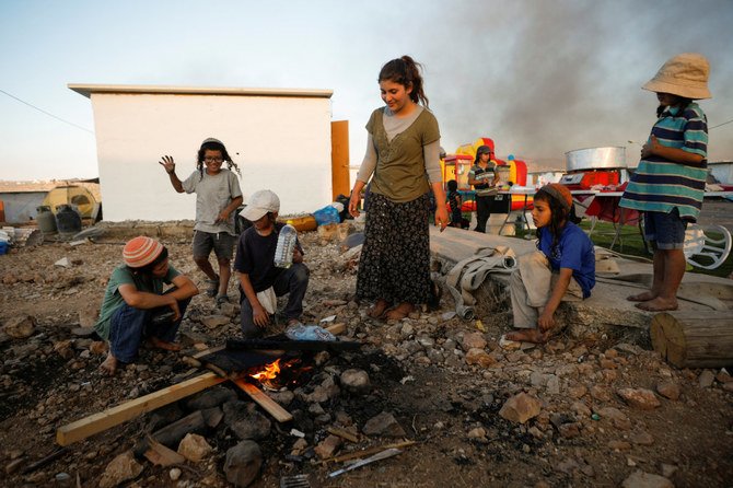 Jewish settler children sit around a fire in Givat Eviatar, a new Israeli settler outpost, near the Palestinian village of Beita in the West Bank on June 23, 2021. (REUTERS/Amir Cohen)