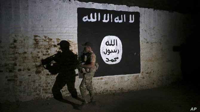 In this March 1, 2017 photo, an Iraqi soldier inspects a tunnel, adorned with an Islamic State flag. (AP file)