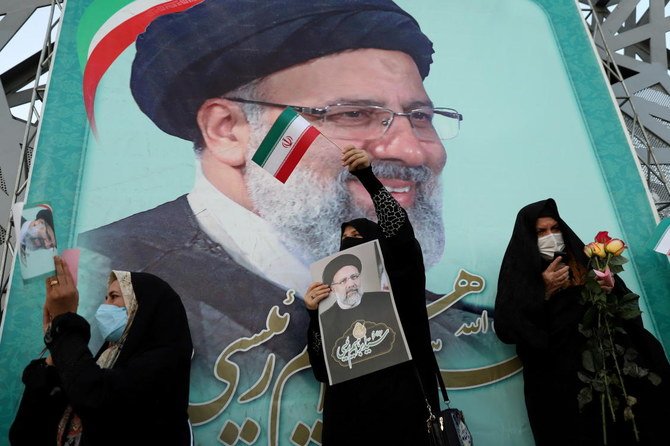 A supporter of Ebrahim Raisi displays his portrait during a celebratory rally for his presidential election victory in Tehran. (Reuters)