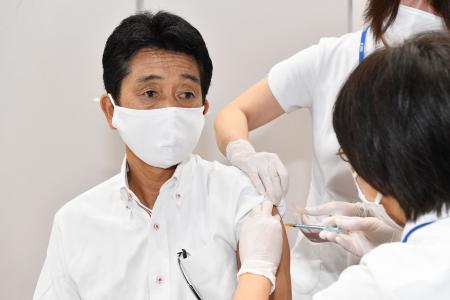 This handout photograph taken on June 1, 2021 and released by AFLOSPORT/JOC shows chef de mission of the Japanese Delegation for Tokyo 2020, Tsuyoshi Fukui (left), receiving a vaccination for Covid-19 in Tokyo. (AFP)