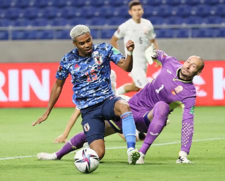 Japan's forward Ado Onaiwu (left) and Kyrgyz Republic goalkeeper Pavel Matiash fight for the ball during the FIFA World Cup Qatar 2022 Asian zone group F qualification football match in Suita, Osaka prefecture on June 15, 2021. (AFP)