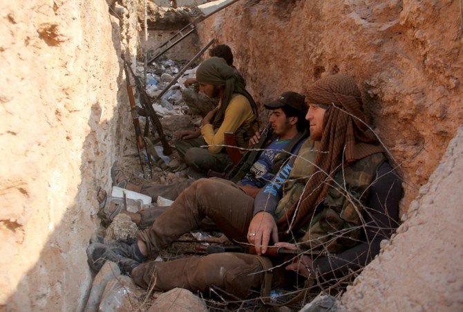 Fighters from the former Al-Nusra Front - renamed Fateh Al-Sham Front after breaking from Al-Qaeda - sit in a trench south of Aleppo on Aug. 6, 2016. (File/AFP)