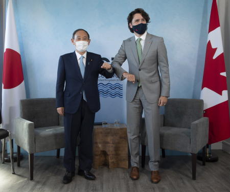 Japanese Prime Minister Yoshihide Suga (left) and Canadian Prime Minister Justin Trudeau pose for a photograph at the start of a bilateral meeting at the G7 Summit in Carbis Bay, southern England, on Sunday. (AP)
