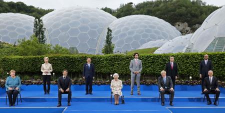 Britain's Queen Elizabeth II (centre), poses for a photograph with, from left, Germany's Chancellor Angela Merkel, President of the European Commission Ursula von der Leyen, France's President Emmanuel Macron, Japan's Prime Minister Yoshihide Suga, Canada's Prime Minister Justin Trudeau, Britain's Prime Minister Boris Johnson , Italy's Prime Minister Mario Draghi, President of the European Council Charles Michel and US President Joe Biden, during an evening reception at The Eden Project in south west England on June 11, 2021. (AFP)