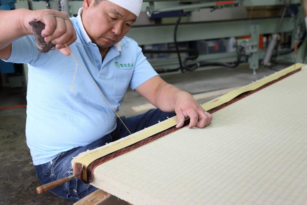Mr. Yamada at work stitching the heri, or the edge of the tatami mat. 