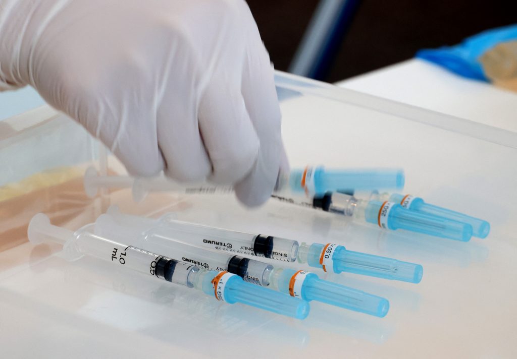 A medical worker picks a syringe to administer the COVID-19 vaccine at the Tokyo Metropolitan Government office in Tokyo, as the government office started vaccinations for people involved in the Tokyo 2020 Olympic Games, June. 18, 2021. (AFP)