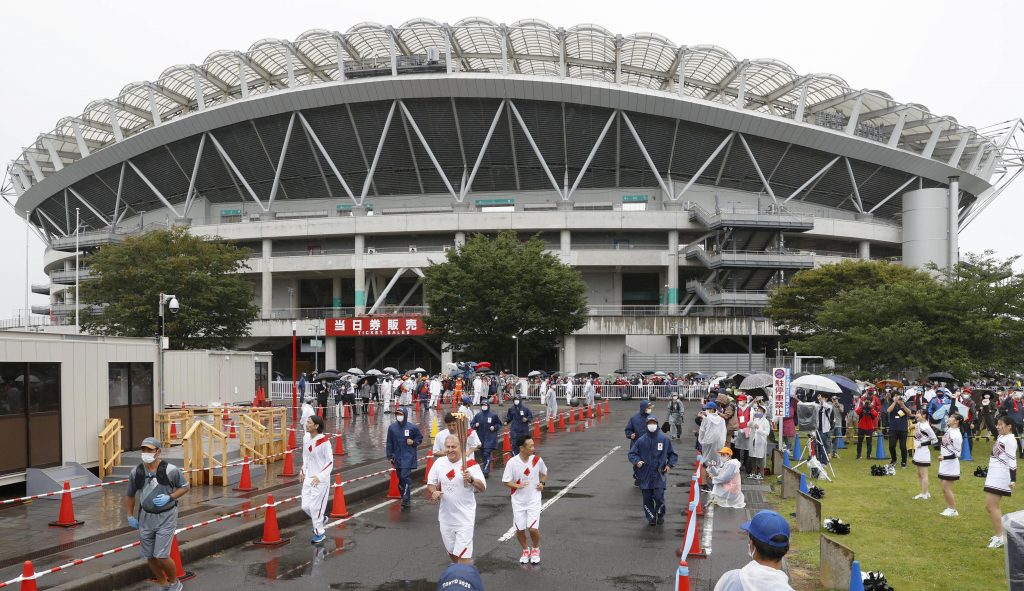 Brazil soccer great Zico, front center, holds the torch for the Tokyo Olympics as he participates in the torch relay with his former team players in Kashima, Ibaraki prefecture, northeast of Tokyo, July 4. 2021. 