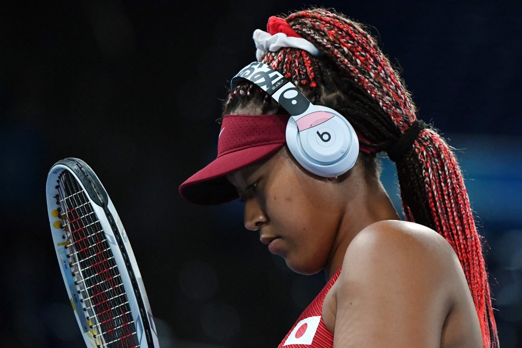 Japan's Naomi Osaka uses headphones during her Tokyo 2020 Olympic Games women's singles third round tennis match against Czech Republic's Marketa Vondrousova at the Ariake Tennis Park in Tokyo on July 27, 2021. (AFP)