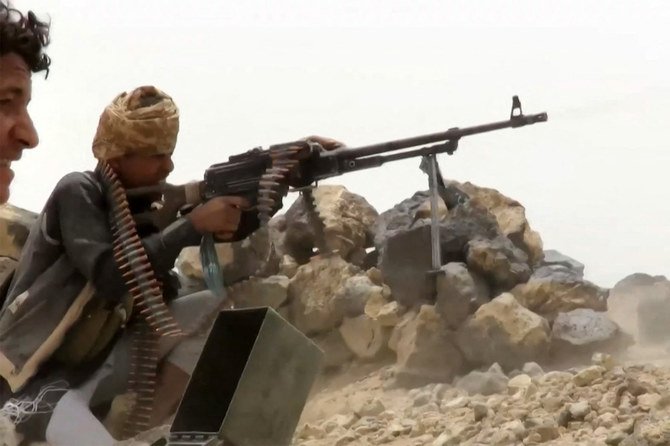 A fighter loyal to Yemen’s government fires a machine gun at Houthi positions, northwest of Marib, June 28, 2021. (AFP)