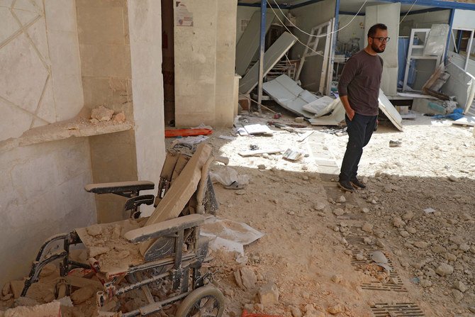 A man stands amid the debris at the entrance of a field hospital in the the village of Atareb in the northern Syrian province of Aleppo on March 21, 2021, after it was reportedly targeted by regime shelling. (AFP)