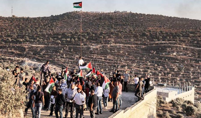 Palestinian protesters gather during a demonstration against the Israeli settlers' wildcat outpost of Eviatar, near the occupied West Bank city of Nablus, on July 6, 2021. (AFP)