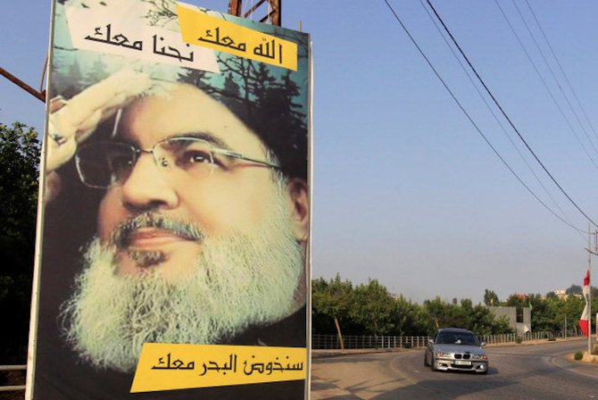 A car drives past a poster depicting Hezbollah leader Sayyed Hassan Nasrallah in Adaisseh village, near the Lebanese-Israeli border, Lebanon, July 28, 2020. (Reuters)