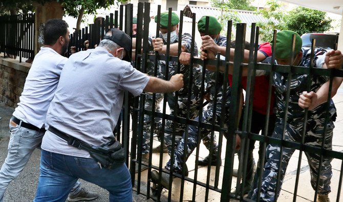 Relatives of people who were killed in last year's massive blast at Beirut's seaport, push a gate as they try to storm the home of caretaker Interior Minister Mohamed Fehmi, in Beirut, Lebanon, Tuesday, July 13, 2021. (AP)