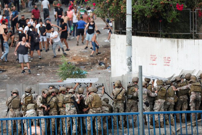 Lebanese army take cover behind shields as they deploy during a protest in Beirut on Thursday after PM-designate Saad al-Hariri abandoned his effort to form a new government. (REUTERS/Mohamed Azakir)