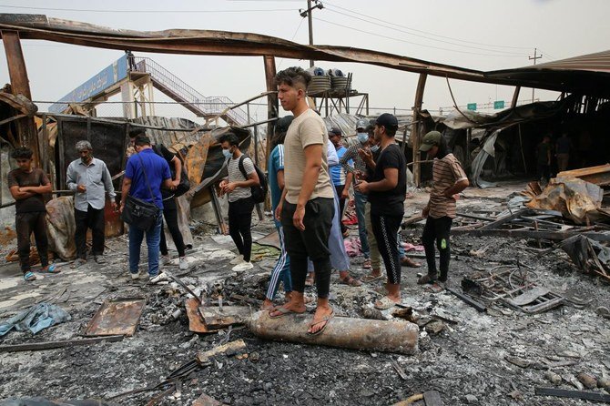 Rescue workers and civilians clean up the fire site at a coronavirus hospital ward in the al-Hussein Teaching Hospital, in Nasiriyah, Iraq, Tuesday, July 13, 2021. (AP)