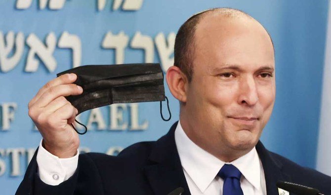 Israeli Prime Minister Naftali Bennett holds a face mask during a news conference in Jerusalem, July 14, 2021. (REUTERS)