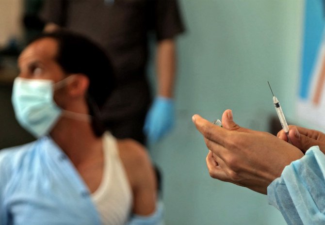 A Yemeni health worker receives a dose of the AstraZeneca COVID-19 vaccine at a vaccination center in Yemen’s third city of Taiz. (File/AFP)