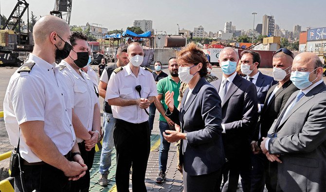 French Ambassador to Lebanon Anne Grillo speaks to crew members at Beirut port as a ship unloads humanitarian aid offered by the French government to Lebanese customs. (AFP)
