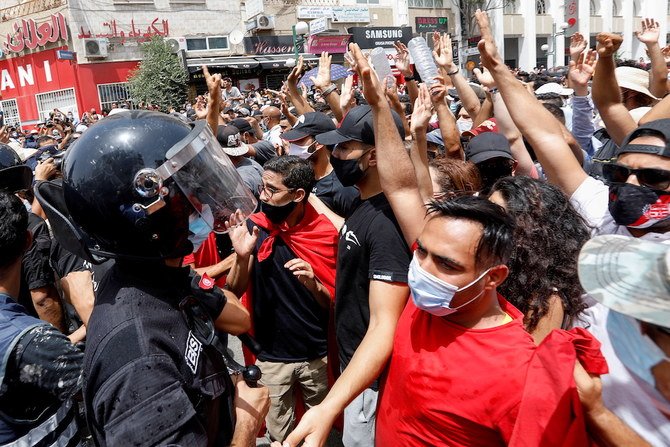 Demonstrators gather in front of police officers standing guard during an anti-government protest in Tunis, Tunisia, July 25, 2021. (AFP)