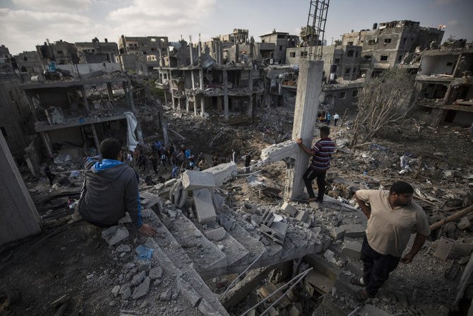 Palestinians inspect their destroyed houses following overnight Israeli airstrikes in town of Beit Hanoun, northern Gaza Strip on May 14, 2021. (AP)