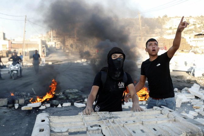 Palestinian protesters watches Israeli soldiers during a protest over the killing of a Palestinian man by Israeli soldiers, according to health ministry, in Beita in the Israeli-occupied West Bank July 28, 2021. (Reuters)