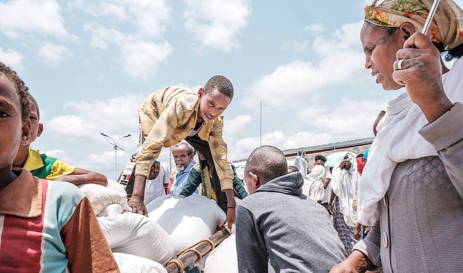 A youngster assists with food distribution organized by the Amhara government near the village of Baker, 50 km southeast of Humera, in Ethiopia’s Tigray Region. (AFP)