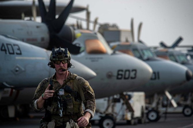 Explosive Ordnance Disposal Technician 3rd Class Ethan Tews walks across the flight deck of aircraft carrier USS Ronald Reagan (CVN 76) in response to a call for assistance from the Mercer Street in the Arabian Sea, July 30, 2021. (Reuters)