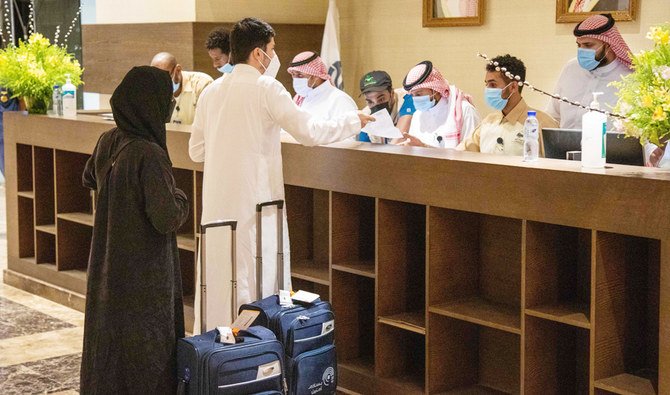 A file photo taken on July 25, 2020, shows travellers arriving for the annual Hajj pilgrimage checking in at the desk at the lobby of a hotel in Makkah. (AFP)