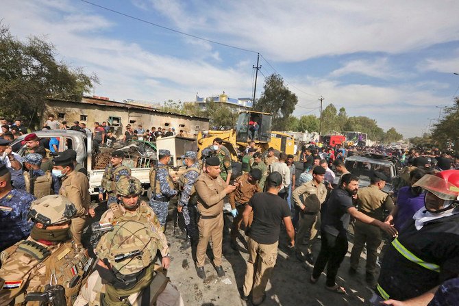 Members of the Iraqi army and security forces gather at the scene of an explosion in the Habibiya district of the Sadr City suburb of Iraq’s capital Baghdad on April 15, 2021. (AFP)